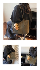 Dettaglio della borsa tote in pelle scamosciata verde oliva con cuciture e ciondolo a orso