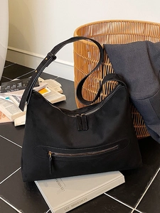 Minimalist black nylon hobo tote bag with adjustable strap and front zipper pocket