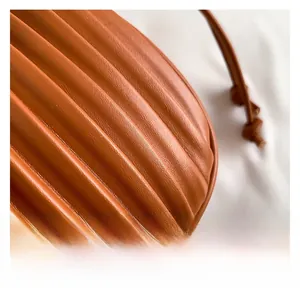 Vue détaillée de la texture en cuir plissé marron caramel d'un sac à main tendance