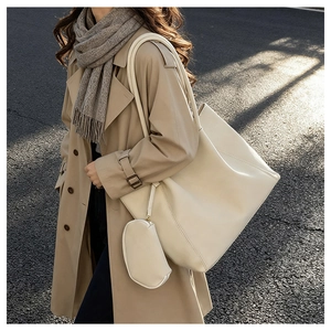 Detailed view of beige faux leather tote bag with matching mini pouch in soft natural light