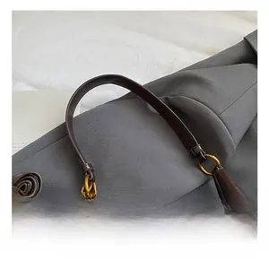 Primo piano della borsa in pelle scamosciata marrone scuro con anelli in metallo dorato