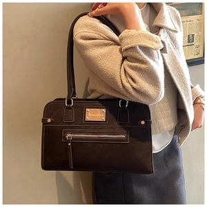 Gros plan d'un grand sac cabas en cuir marron foncé porté à l'épaule par un mannequin