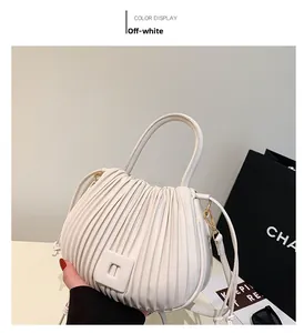 Détail du sac à main en cuir plissé blanc cassé avec poignée ronde élégante