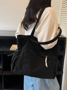 Large black corduroy tote bag for women featuring front zipper pocket and side drawstrings