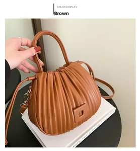 Vue détaillée d'un sac à main en cuir plissé marron avec crochets dorés et bandoulière