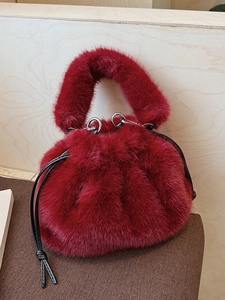 Burgundy faux fur bucket bag with drawstring closure and soft plush top handle