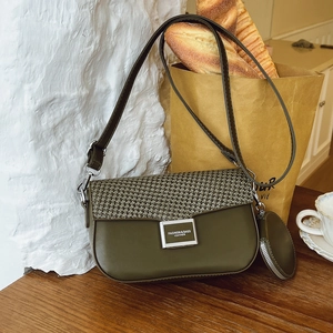 Detail of green crossbody bag with textured flap and mini coin purse in a French cafe setting