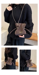 Detail of dark brown frosted chain bucket bag showing drawstring closure and fashion text