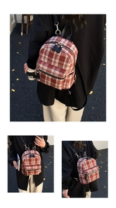 Detail view of red plaid pattern texture and adjustable black straps of the backpack