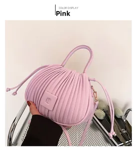 Détail du sac à main plissé rose avec boucle carrée et garnitures dorées en situation