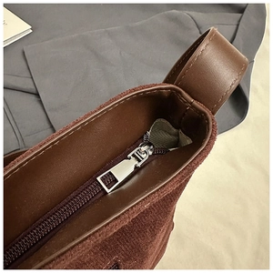 Gros plan détaillé du sac cabas en daim marron foncé avec fermeture à glissière en argent