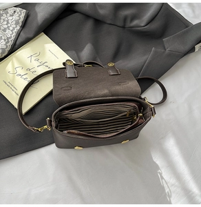 Detail of dark brown messenger bag with striped lining and inner zipper pocket