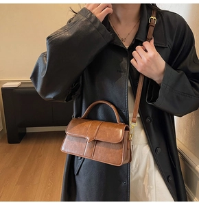 Détail du sac en cuir PU marron avec coutures verticales et finitions dorées chic