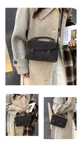 Detail of vintage charcoal grey crossbody bag with matte leather and golden buckles