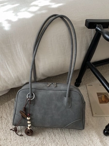 Minimalist grey suede shoulder bag with unique long handles and ethnic bead pendant decoration