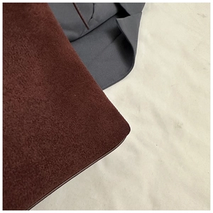 Gros plan sur la texture en suédine mate rouge foncé d'un grand sac cabas fourre-tout