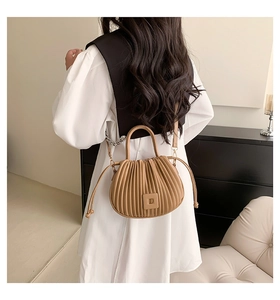 Détail du sac bandoulière plissé camel montrant la texture et le porté par le mannequin