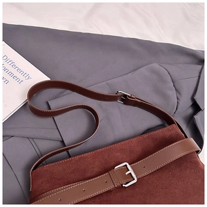 Détail du sac cabas en daim marron avec bandoulière en cuir réglable et boucle argentée
