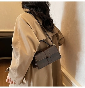 Dark brown vintage leather square bag styled with khaki trench coat for a winter look
