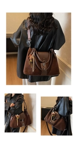 Detail of large brown suede tote bag with leather flap and cute bear pendant accessory