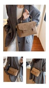Detail of vintage brown crossbody bag featuring dual buckles and matte finish texture