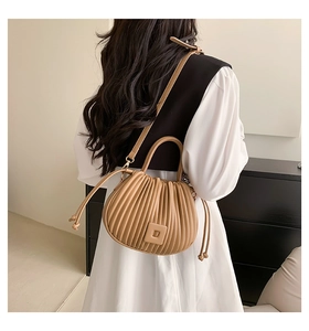 Vue détaillée du sac bandoulière beige plissé en cuir souple avec boucle décorative carrée