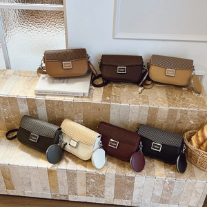 Multiple colors of woven crossbody bags with matching round coin purses on stone steps