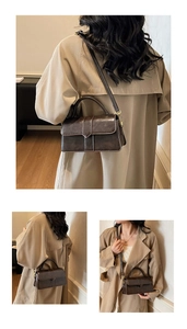 Detail view of a vintage dark brown square handbag with gold hardware and top handle