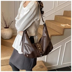 Close-up of brown faux leather hobo bag with vintage silver star studs and ring detail