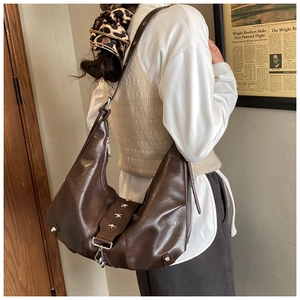 Detail view of large dark brown hobo bag with silver star rivets and adjustable strap