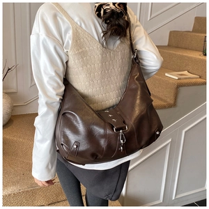 Detail view of brown tote bag featuring silver star studs and vintage leather texture