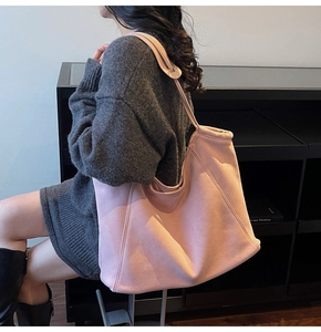 Detail of pink faux suede tote bag showing soft texture and large capacity on shoulder