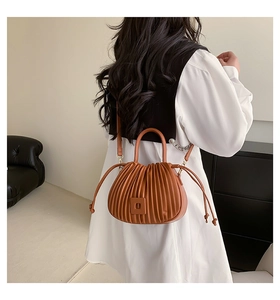 Détail du sac à main plissé en cuir PU caramel montrant les plis verticaux et l'anse