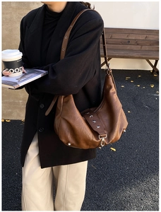 Detailed view of dark brown hobo bag with iconic silver star rivets and soft leather texture