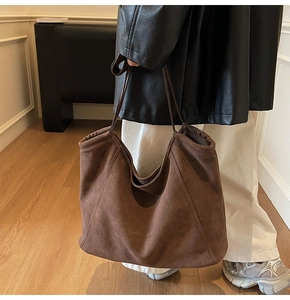Detailed texture of brown suede tote bag styled with casual winter outfit and long straps