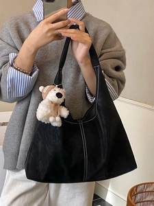 Black minimalist tote bag with contrast stitching and plush bear charm for daily casual wear