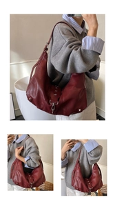 Detailed macro view of dark red vintage leather tote with silver star metal rivets