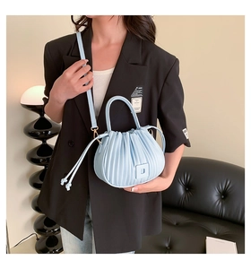 Détail du sac à main plissé bleu clair avec poignée supérieure et fini cuir mat