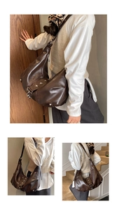 Detail of dark brown faux leather hobo bag with silver star hardware and wide strap