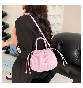 Détail du sac croissant plissé rose clair avec boucle carrée et texture en cuir PU doux