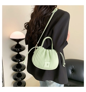 Détail du sac bandoulière vert menthe avec design plissé et boucle carrée élégante