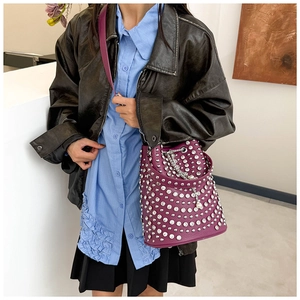 Détail du sac seau violet avec clous argentés, chaîne de perles et bandoulière en cuir