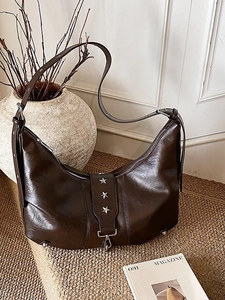 Vintage dark brown leather crescent tote bag with star rivets and adjustable shoulder strap