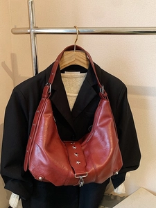 Retro dark red leather tote bag with silver star rivets on a wooden hanger display