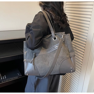 Dettaglio borsa tote grigio scuro con cuciture a contrasto e tasca con zip metallica