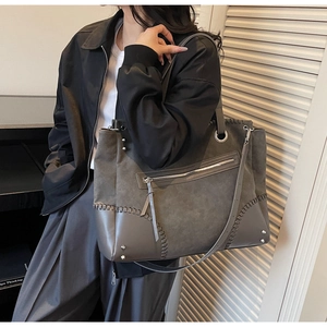 Dettaglio della borsa tote grigia opaca vintage con cuciture a contrasto e accenti di rivetti
