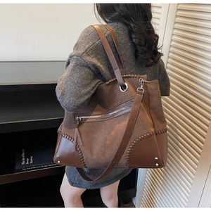 Dettaglio della borsa tote marrone vintage con patchwork in pelle scamosciata e cuciture