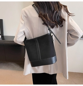 Detailed back view of a minimalist black bucket bag styled on a model for daily commute