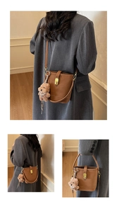 Brown leather bucket bag with gold hardware and plush bear charm shown in multiple views