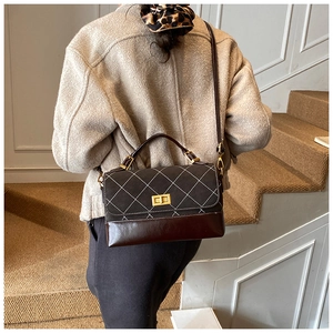 Close-up of retro color-block handbag with diamond quilting and gold twist lock clasp